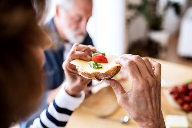 istock Senior couple eating breakfast at home. 909886306