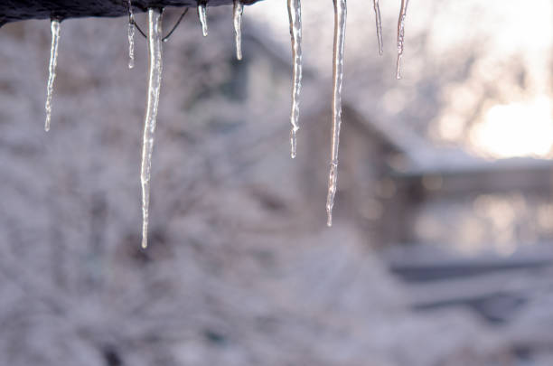 istock Beautiful row of hanging icicles on a blurred white background. 909891356