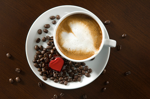 A cup of coffee latter with red color heart shape latte art