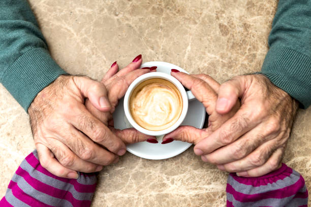 istock Senior couple holding hand during morning coffee 909902900