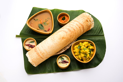 Masala dosa with chutney and sambar and potato sabzi. Dosa is a pancake from south India typically in Cone, triangle or roll shape, selective focus