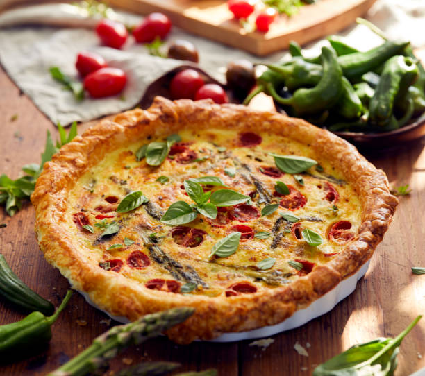 istock Quiche with cherry tomatoes and green asparagus sprinkled with fresh herbs 909907220