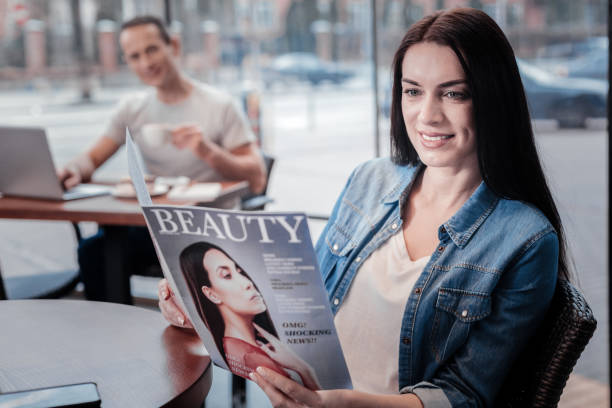 istock Attractive female person reading glossy magazine 909907652