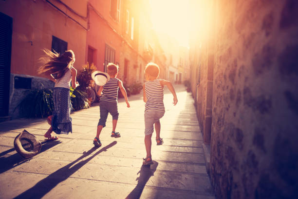 istock Kids playing tag in mediterranean street 909908494