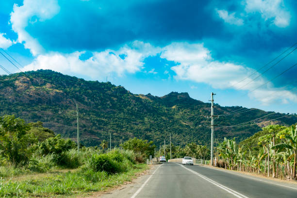 Typical country road seen near the city of Nadi, Fiji Islands, during a hot day.