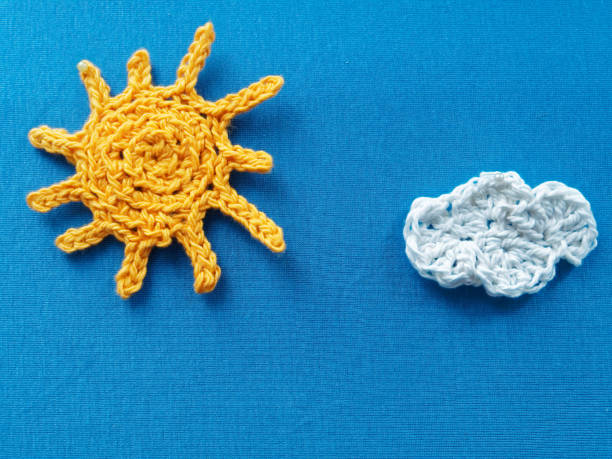 istock Crochet sun and cloud on knitted fabric 909911900