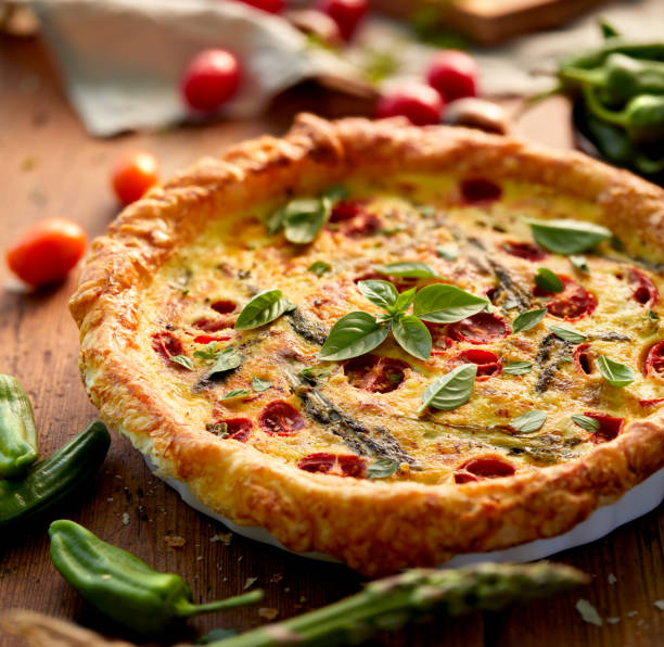 istock Quiche with cherry tomatoes and green asparagus sprinkled with fresh herbs 909914082