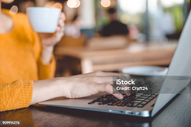 Young Beautiful Businesswomen Wearing A Yellow Sweater Enjoying Coffee Stock Photo - Download Image Now