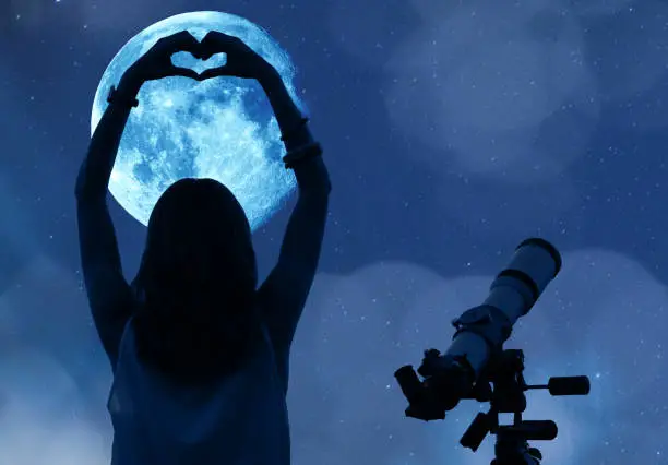 Photo of Girl holding a heart - shape with telescope, Moon and stars. My astronomy work.