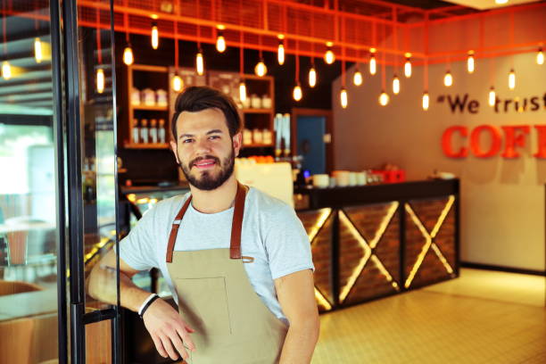 istock Smiling male barista preparing coffee 909918318