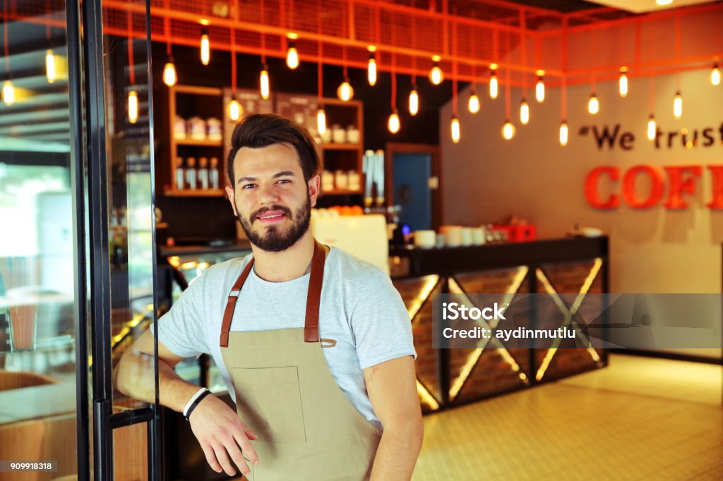 Smiling male barista preparing coffee Apron Stock Photo