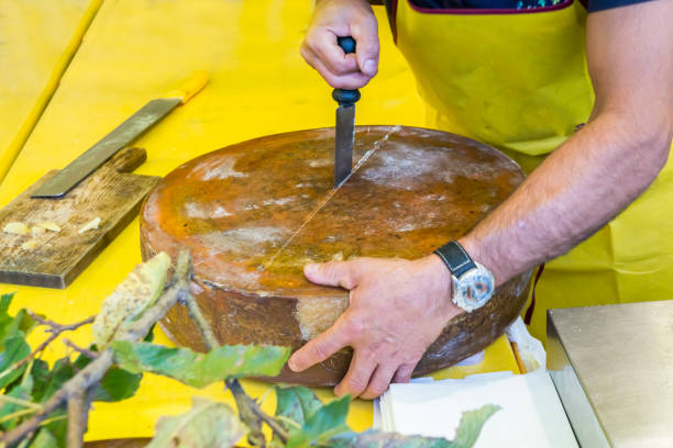 istock Cutting hard cheese in grocery shop 909918470