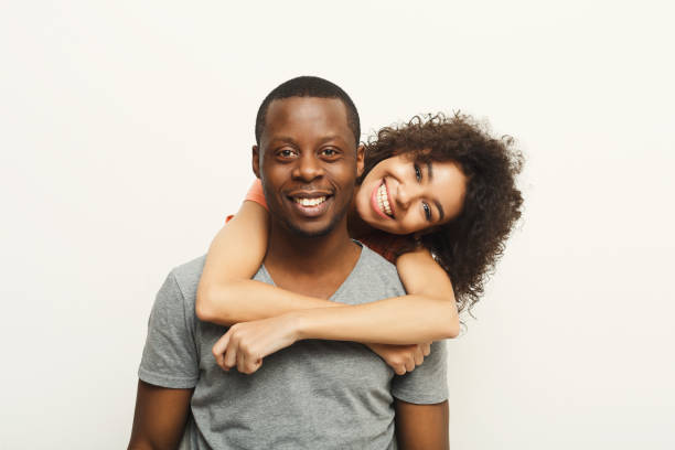 istock Black couple hugging and posing at white background 909918544