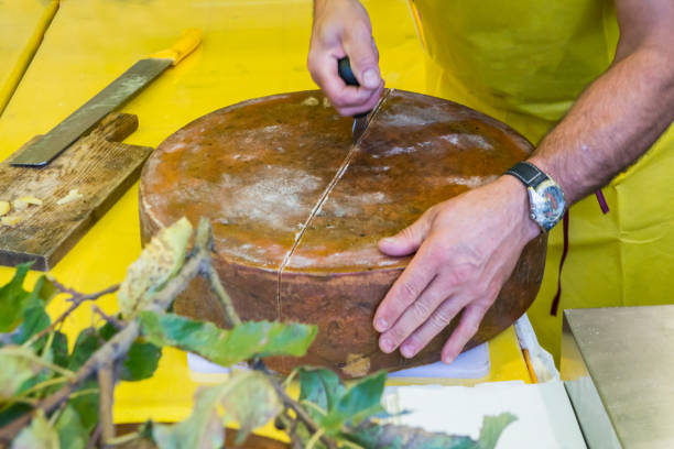 istock Cutting hard cheese in grocery shop 909918832