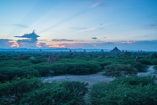View of Bagan archeological zone at sunset in the monsoon season from a temple's roof. Stunning landscape with stupas, monasteries and temples. Bagan counts more than 2200 temples and stupas in the present day.