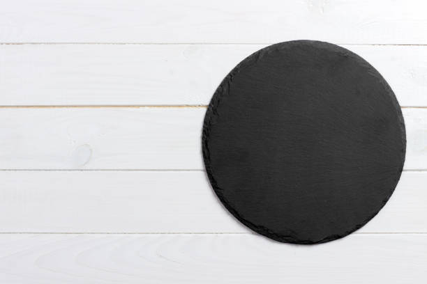 istock Round slate stand board a wooden background. space for text 909927166