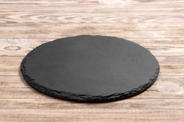 istock Round slate stand board a wooden background. space for text 909927168