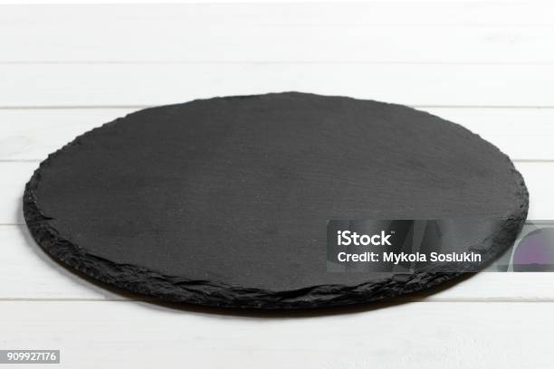 Black Slate Round Stone On Wooden Background Top View Copy Space Stock Photo - Download Image Now