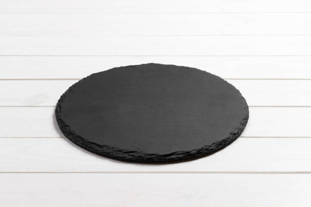 istock Slate plate on table. black slate stone on wooden background. copy space 909927188