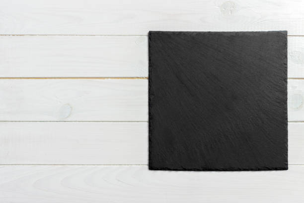istock slate board on wooden background, space for writing text 909927234