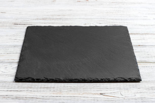 istock Slate board over old wooden background with copy space 909927316