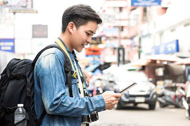 istock Asian tourist backpacker using tablet while traveling  in Khao San road Thailand 909927760