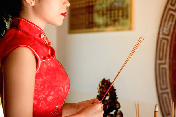 istock Asian woman praying with incense sticks during Chinese new year 909927770