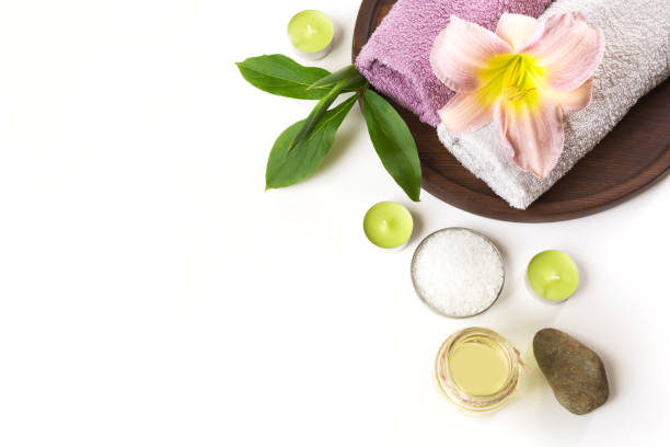 Spa setting of towel, flower on white background with copy space. Close up. Top view.