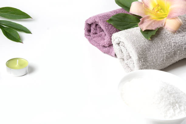 istock Spa setting of towel, flower, coffee beans on white background with copy space. Relax. 909927936