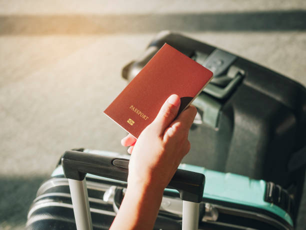 istock Hand holding Passport Traveler with Luggage Travel concept 909930708