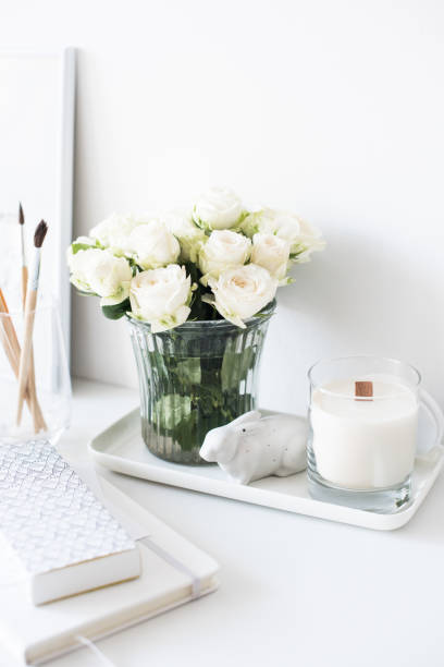 istock White interior decor with new hand-made candle and bouquet of fr 909930896