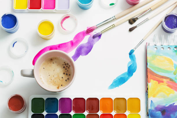 istock paints, brushes and cup of coffee on paper 909931524