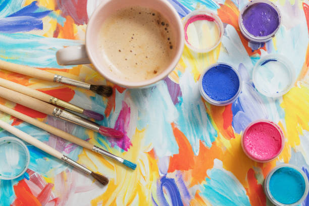 istock paints, brushes and cup of coffee on paper 909931572