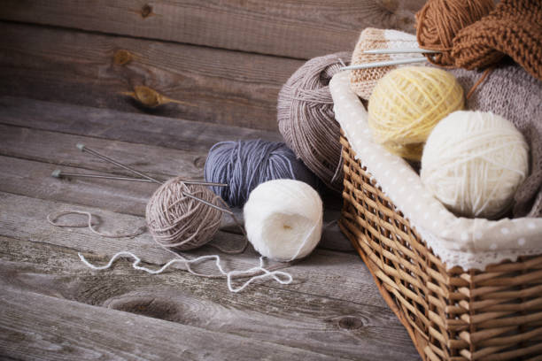 istock Knitting and knitting needles on a wooden surface 909931634