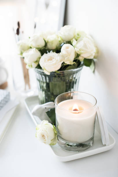 istock White room interior decor with burning hand-made candle and bouq 909931748