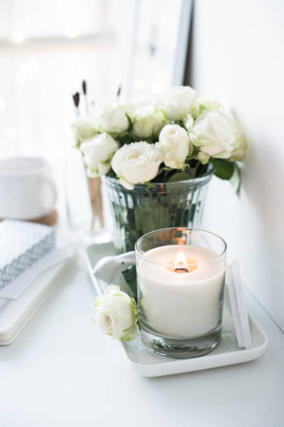 istock White room interior decor with burning hand-made candle and bouq 909931788