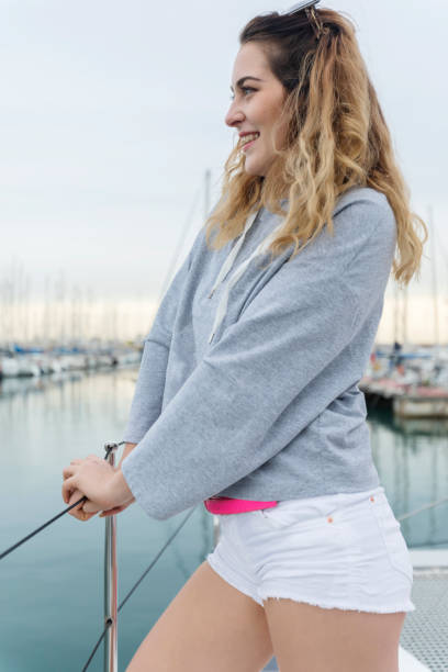 istock woman staying on the sailboat during sunset 909932120