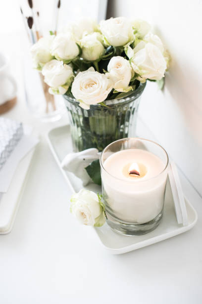 istock White room interior decor with burning hand-made candle and bouq 909932146