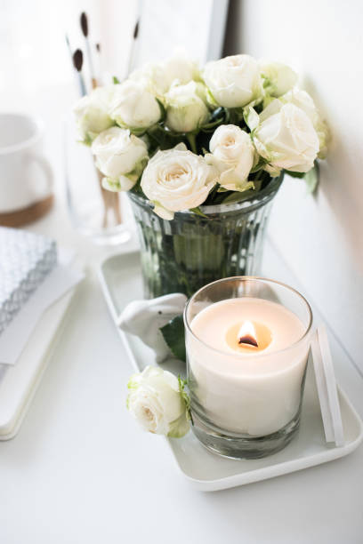 istock White room interior decor with burning hand-made candle and bouq 909932220