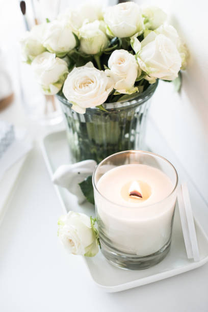 istock White room interior decor with burning hand-made candle and bouq 909932378