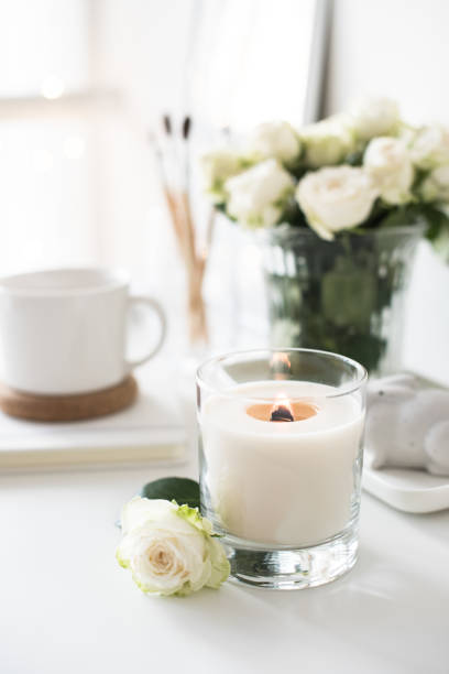 istock White room interior decor with burning hand-made candle and bouq 909934700