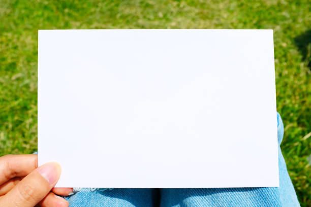 istock holding a white paper on the grass 909934746