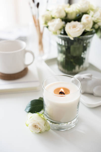istock White room interior decor with burning hand-made candle and bouq 909934768