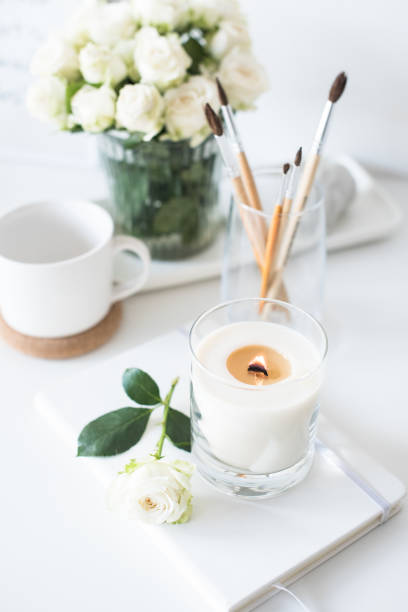 istock White room interior decor with burning hand-made candle and bouq 909934962