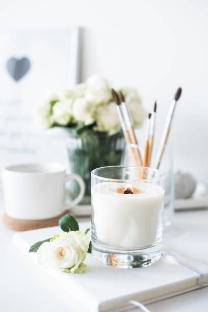 istock White room interior decor with burning hand-made candle and bouq 909934994