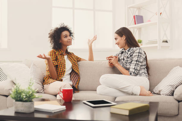 istock Two young female friends with coffee conversing 909935768