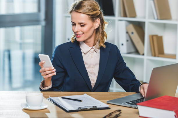 istock businesswoman with smartphone at workplace 909938284