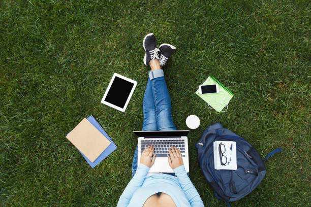 istock Girl with laptop on the grass 909938876
