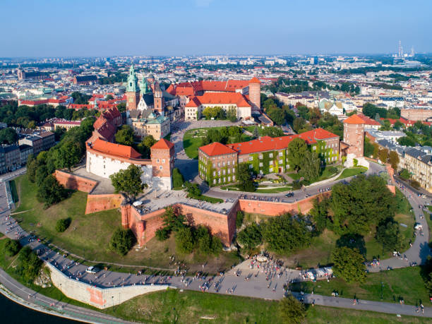 Krakow skyline, Poland, with Wawel Hill, Cathedral and castle Krakow, Poland - August 26, 2017: Skyline panorama of Cracow old city with Wawel Hill, Cathedral, Royal Wawel Castle, defensive walls, park, promenade and unrecognizable walking people. wawel cathedral stock pictures, royalty-free photos & images
