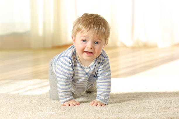 istock Happy baby crawling towards camera at home 909946070